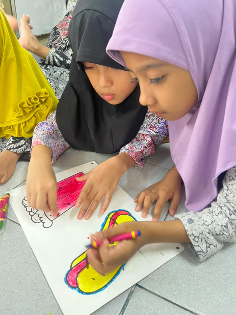 Gambar 6. Dua peserta mewarnai gambar dengan penuh konsentrasi